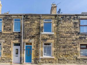 an old stone house with blue doors and windows at 3 Bed in Amble 83995 in Amble