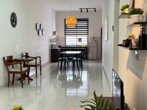 - une cuisine et une salle à manger avec une table et des chaises dans l'établissement Desaru Cozy NetFlix WiFi 24LV9 By De Home, à Bandar Penawar