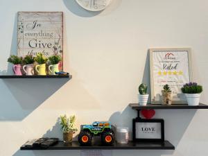 Une étagère avec des plantes et un camion de jouets sur elle dans l'établissement Desaru Cozy NetFlix WiFi 24LV9 By De Home, à Bandar Penawar