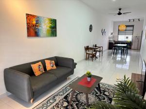 - un salon avec un canapé et une table dans l'établissement Desaru Cozy NetFlix WiFi 24LV9 By De Home, à Bandar Penawar