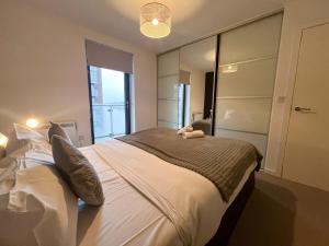 una camera da letto con un grande letto e un grande specchio di Riverside Retreat with Spectacular Views Glasgow a Glasgow