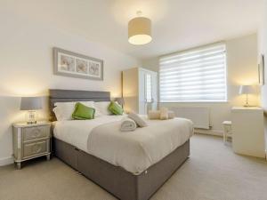 a bedroom with a large bed with green pillows at 3 Bed in Wooler 83975 in Wooler