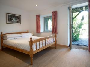 a bedroom with a wooden bed and a large window at 3 Bed in Haile SZ230 in Hale