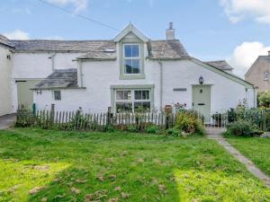 a white house with a fence in the yard at 3 Bed in Bassenthwaite 84024 in Bassenthwaite