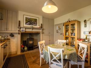 a kitchen with a table and chairs and a fireplace at 2 Bed in Threlkeld SZ082 in Threlkeld