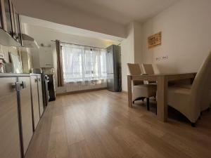 eine Küche und ein Esszimmer mit einem Tisch und einem Kühlschrank in der Unterkunft 2 Comfy Rooms Apartment in Iaşi
