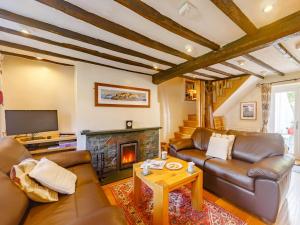 a living room with leather furniture and a fireplace at 2 Bed in Portinscale SZ341 in Portinscale