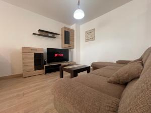 ein Wohnzimmer mit einem Sofa und einem Flachbild-TV in der Unterkunft 2 Comfy Rooms Apartment in Iaşi