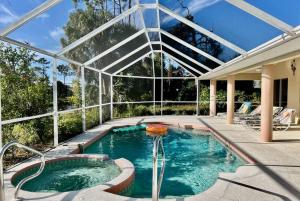 a swimming pool in a house with a glass ceiling at Villa with swimming pool & spa in quiet area in Rotonda West