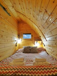 a bed in a log cabin with an attic at Vila Jelena - BUNGALOV in Crni Vrh