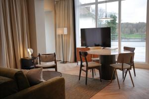 een woonkamer met een bank en een tafel met stoelen bij By Friso Den Haag in Scheveningen