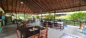 un restaurante al aire libre con mesas y sillas de madera en La Joviseña, en Nuquí