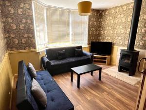 uma sala de estar com um sofá e um fogão em Inviting 4-Bed House near Heathrow with fireplace em Egham
