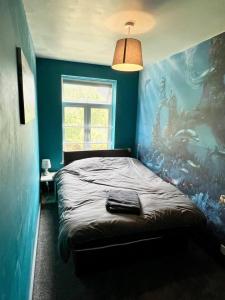 a bedroom with a bed with a painting on the wall at Inviting 4-Bed House near Heathrow with fireplace in Egham