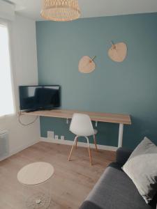 a living room with a couch and a table and a chair at O'ZEN - studio calme et lumineux avec jardin in Sablé-sur-Sarthe