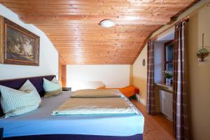 - une chambre avec un lit et un plafond en bois dans l'établissement Ferienwohnung Hötzelsperger, à Prien am Chiemsee