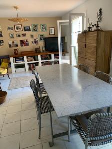 een eetkamer met een grote marmeren tafel en stoelen bij Appartement supérieur sur l 'étang in Sète