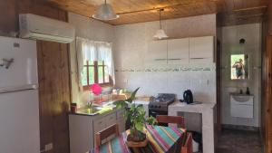a kitchen with a refrigerator and a table with chairs at Cabaña Los Abuelos in Coronel Moldes