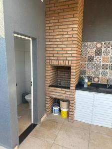 a brick fireplace in a bathroom with a toilet at CASA DE PRAIA OLONAN BEACH in Itanhaém