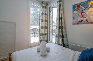 um quarto com uma cama com toalhas em Apartment Triolet Jardin em Chamonix-Mont-Blanc