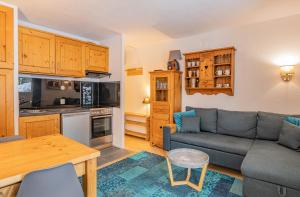 uma sala de estar com um sofá e uma cozinha em Apartment Triolet Jardin em Chamonix-Mont-Blanc