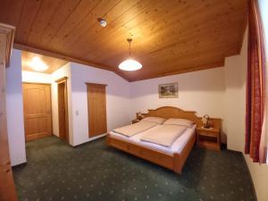 een slaapkamer met een bed en een houten plafond bij Gästehaus Toferer in Grossarl