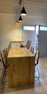 una gran mesa de madera con sillas en una habitación en Casa Monte hermoso a media cuadra Del Mar en Monte Hermoso