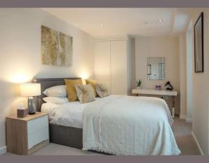 a bedroom with a bed and a table with a lamp at Westminster 2 bed 2 bath apartment in London