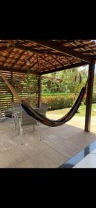 a hammock in a pavilion with a table and chairs at bangalô Lucena in Lucena