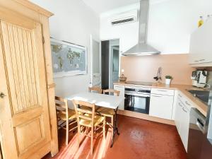 een keuken met een tafel en stoelen en een keuken met witte kasten bij LE TOIT de la rue Sainte in Marseille