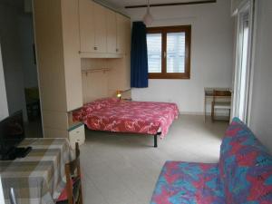 Un dormitorio con una cama roja y una silla. en President Frontemare - Agenzia Cocal, en Caorle