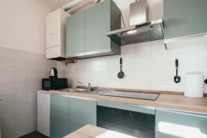 a kitchen with white cabinets and a sink at Bigattera trilocali - Affitti Brevi Italia in Varese