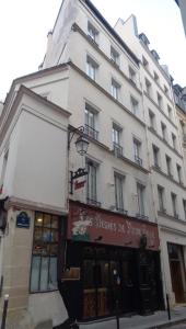 فندق ليه ديغريه دو نوتر دام في باريس: مبنى ابيض كبير على زاوية شارع
