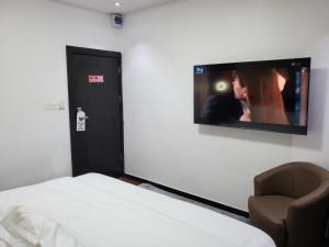 a room with a bed and a tv on a wall at Hotel Thirty Five in Lagos