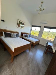 1 dormitorio con 2 camas y lámpara de araña en Casa Abundia, en Carrillo