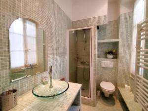 een badkamer met een glazen wastafel en een toilet bij LE TOIT de la rue Sainte in Marseille