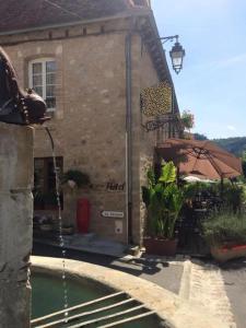 un bâtiment avec une piscine en face d'une maison dans l'établissement Auberge de La Fontaine, à Autoire