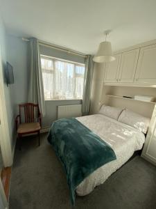 a bedroom with a bed and a chair and a window at Baldara House in Dublin