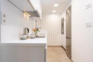 una cucina con ripiani bianchi e frigorifero di Genteel Home Infinity a Estepona