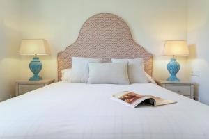 un letto con un libro su cui sono montate due lampade di Genteel Home Infinity a Estepona Altre 13 foto
