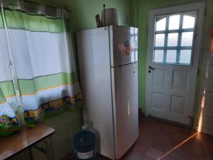 einen weißen Kühlschrank in einer Küche mit Fenster in der Unterkunft El Marino in Merlo