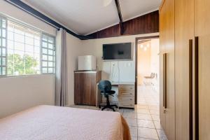 a bedroom with a bed and a desk and a chair at Suite Vista Panorâmica in Betim