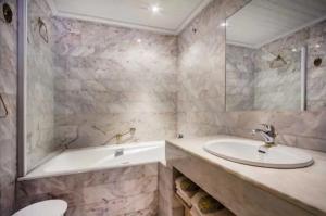 a bathroom with a tub and a sink and a bath tub at Arc de triomphe studio charme authentique in Paris