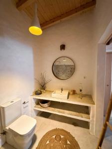uma casa de banho com um WC branco e um lavatório. em Papoila em Grândola