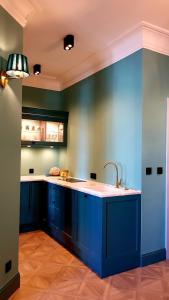 a kitchen with blue cabinets and a sink at Old Town Apartment A in Warsaw