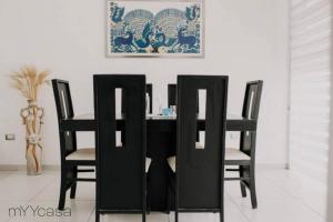 a black dining room table with four black chairs at Spectacular House w/ Pool & Amazing Location 