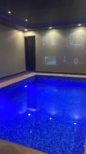 - une piscine avec des lumières bleues dans une chambre dans l'établissement شاليهات يارا القيروان, à Riyad