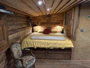 ein Schlafzimmer mit einem Bett und einem Stuhl in einem Zimmer in der Unterkunft La Grenouillette in Mirwart