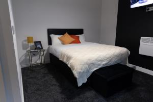 Dormitorio pequeño con cama con almohadas de color naranja en Credit Corner, en Brierley Hill