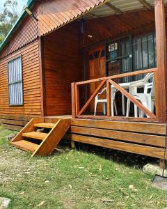 Cabaña de madera con porche y puerta en Cabaña La Mañana Siguiente, en La Pedrera